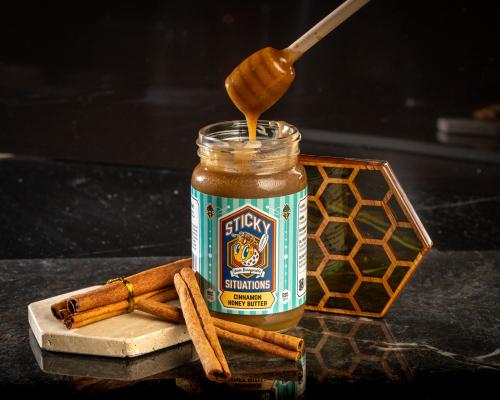 cinnamon honey butter with honey dipper going into top and cinnamon sticks on left